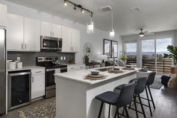 A modern kitchen with a large island and bar stools.